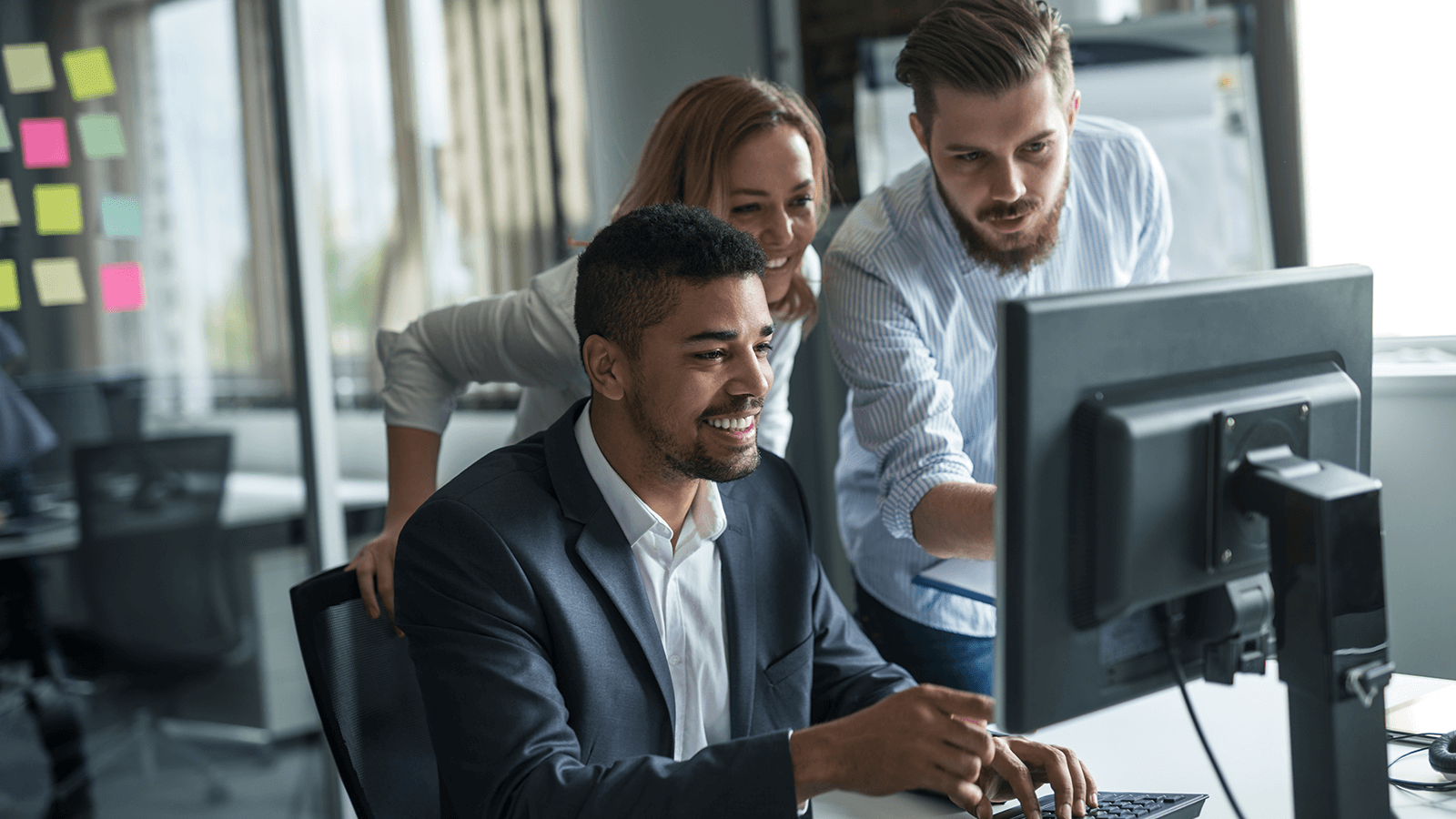 colleagues collaborating around computer screen