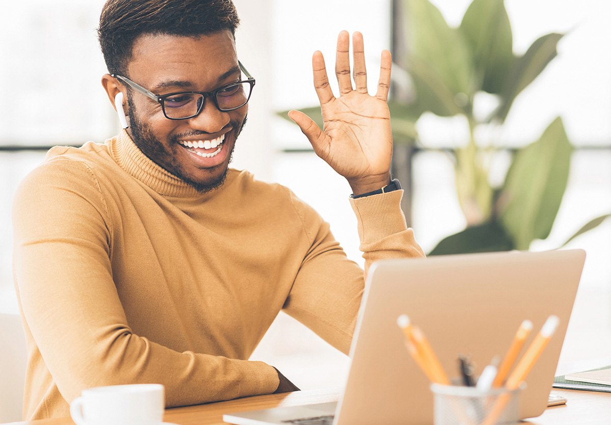man waving at computer