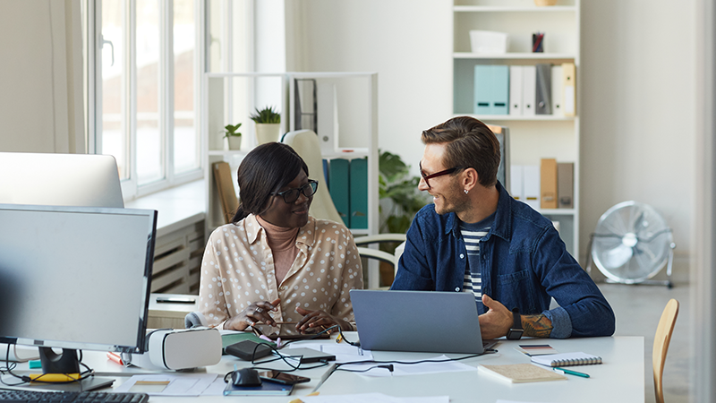 helpful person explaining technology to colleague
