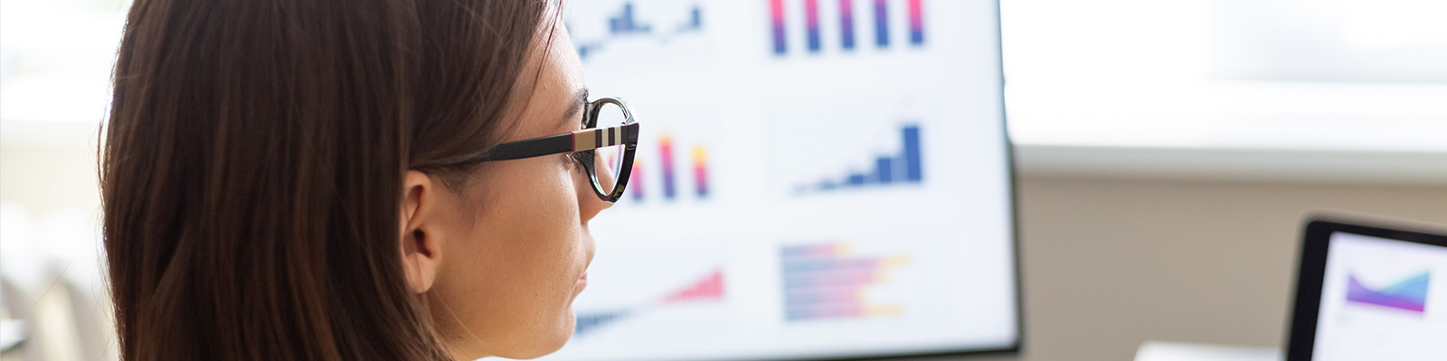 photo of woman looking at graphs