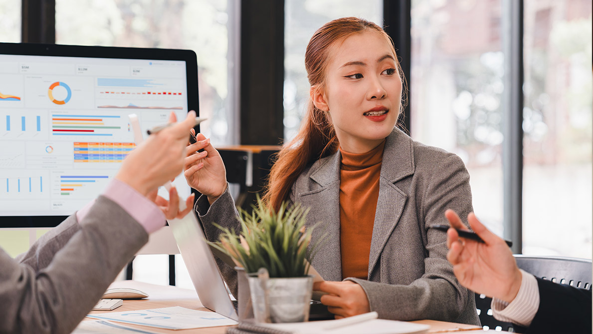 Lady in discussion about learning impact at table with colleagues