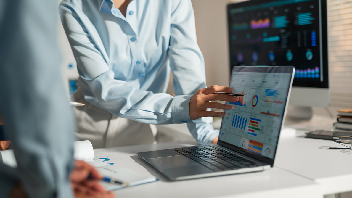 Two individuals discussing learning success measurement on a laptop screen