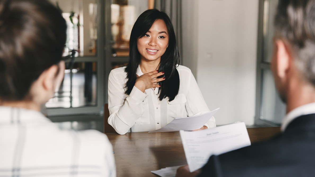 A learner sits in a 1-2-1 interview with two managers